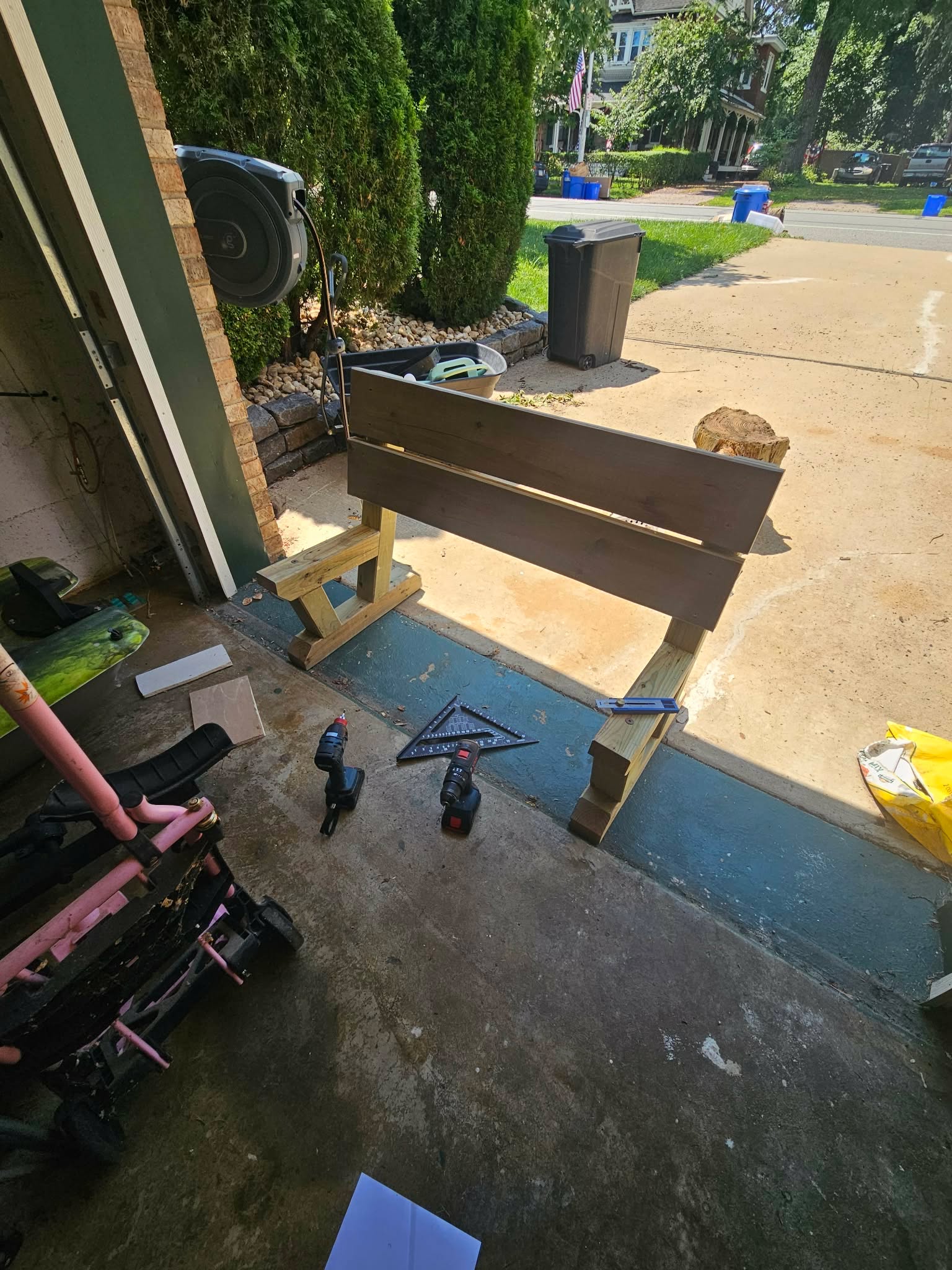 The full bench frame assembled, still unstained, standing in the garage