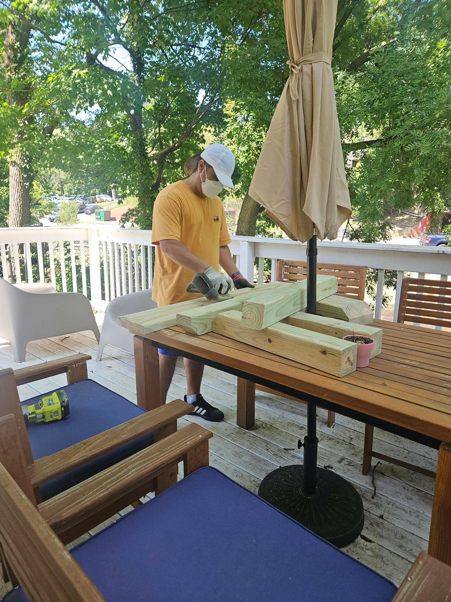 Sanding the cut boards on the deck table with an orbital sander