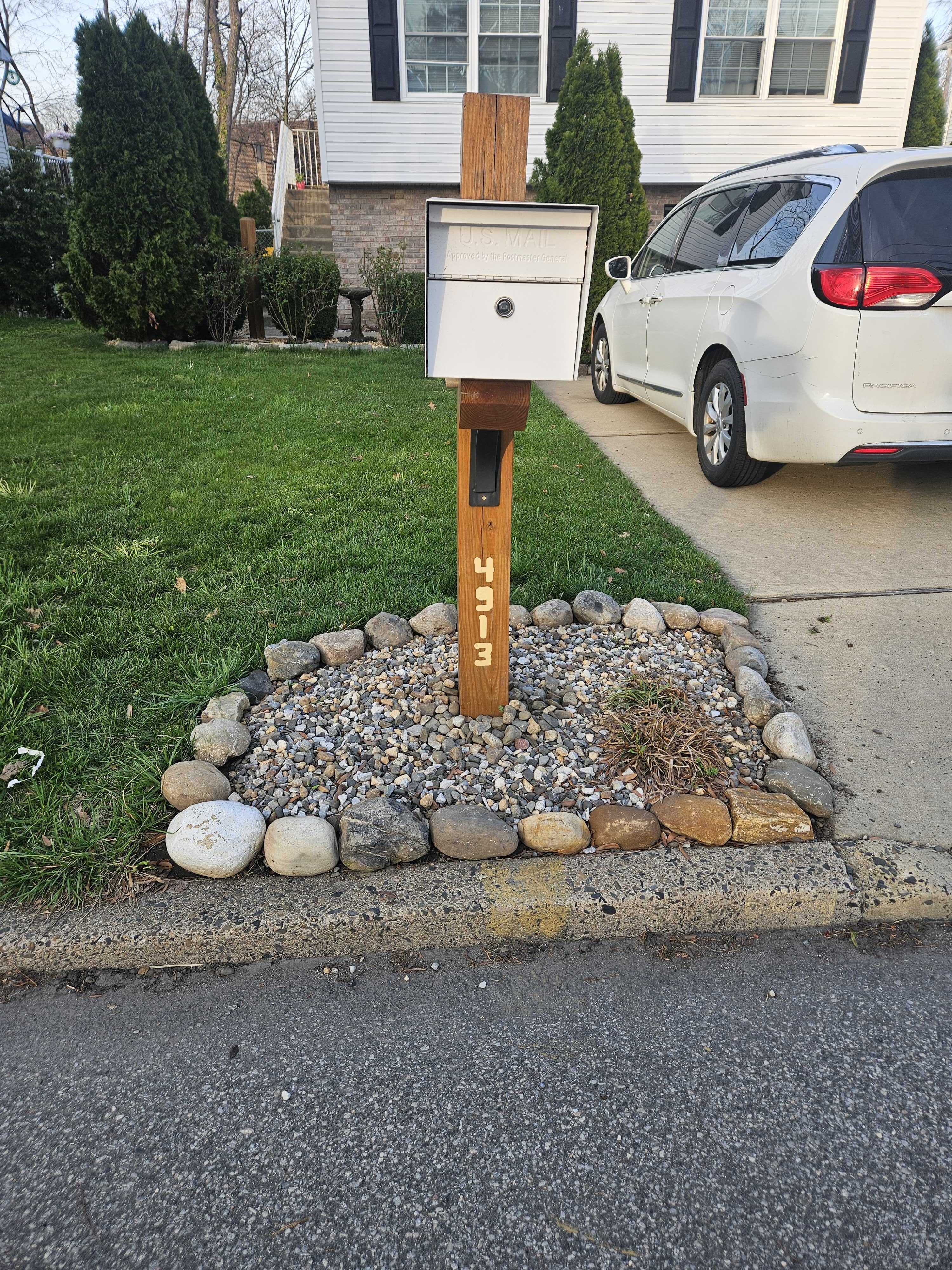 The completed custom timber mailbox post installed at the front of the house