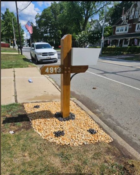The completed mailbox post from the street — side view