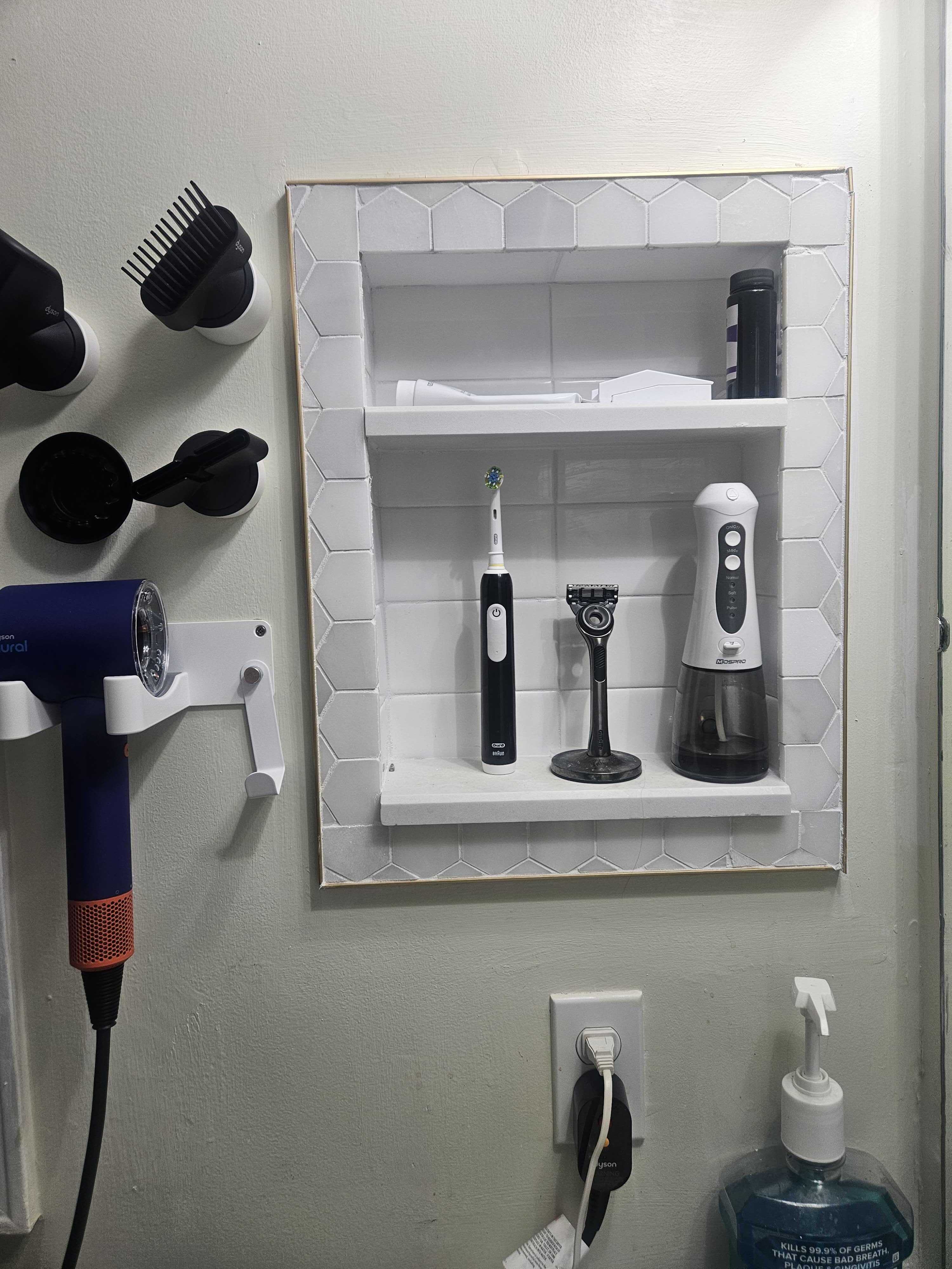 The completed tiled recessed shelf with hexagon border tile and two shelves