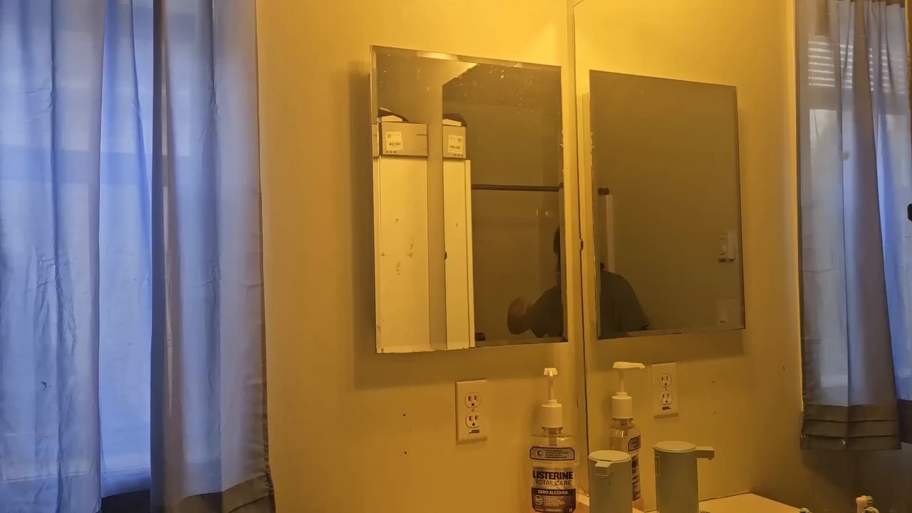 The old medicine cabinet before removal — mirrored door, old hardware