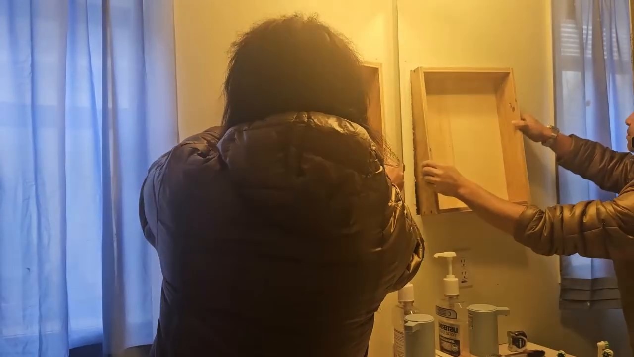 Fitting the custom wood shelf box into the wall opening