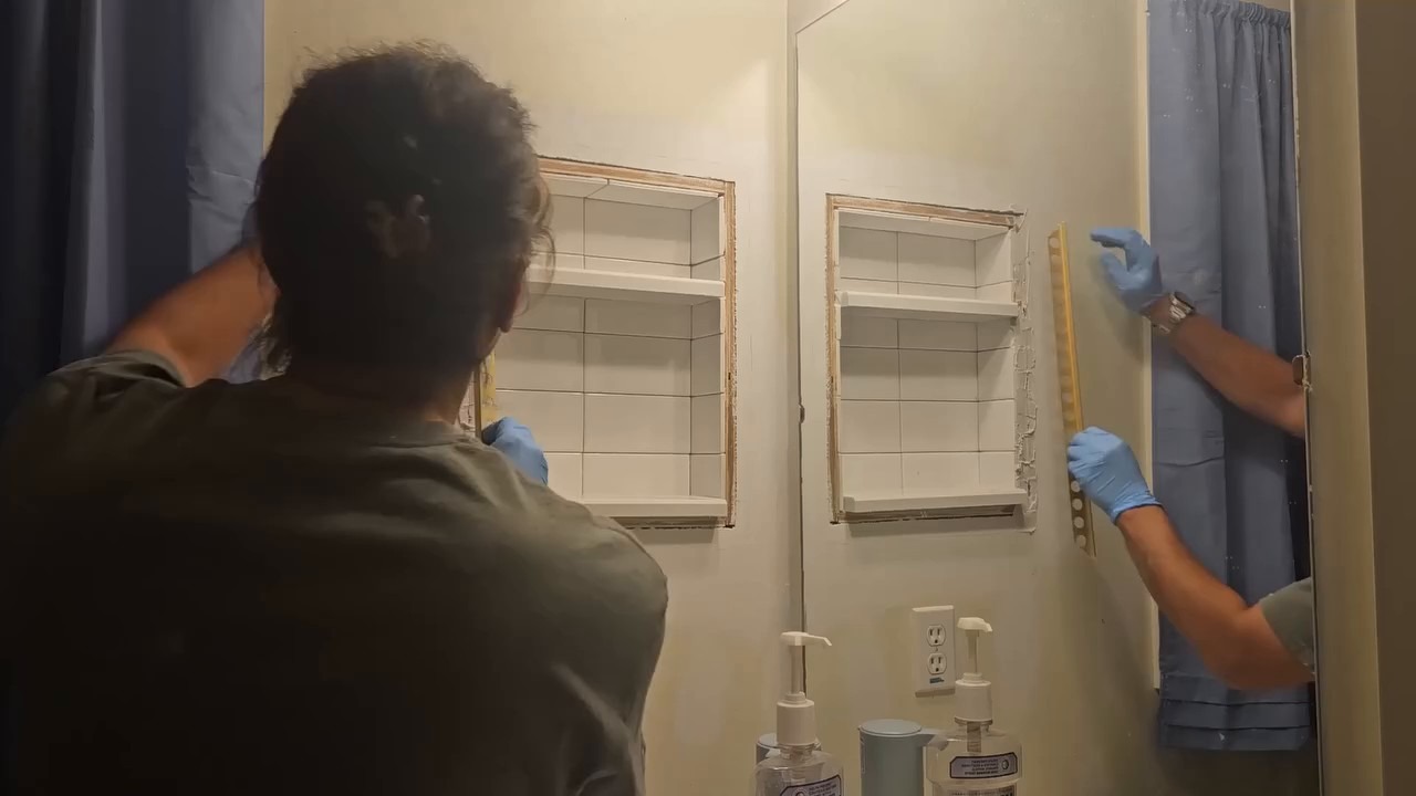 Applying grout to the hexagon decorative tile border with blue gloves