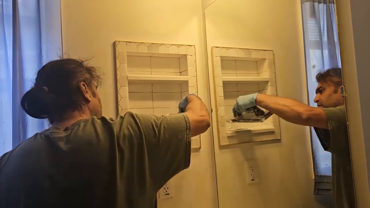 Checking and fitting the trim frame against the wall around the tiled shelf