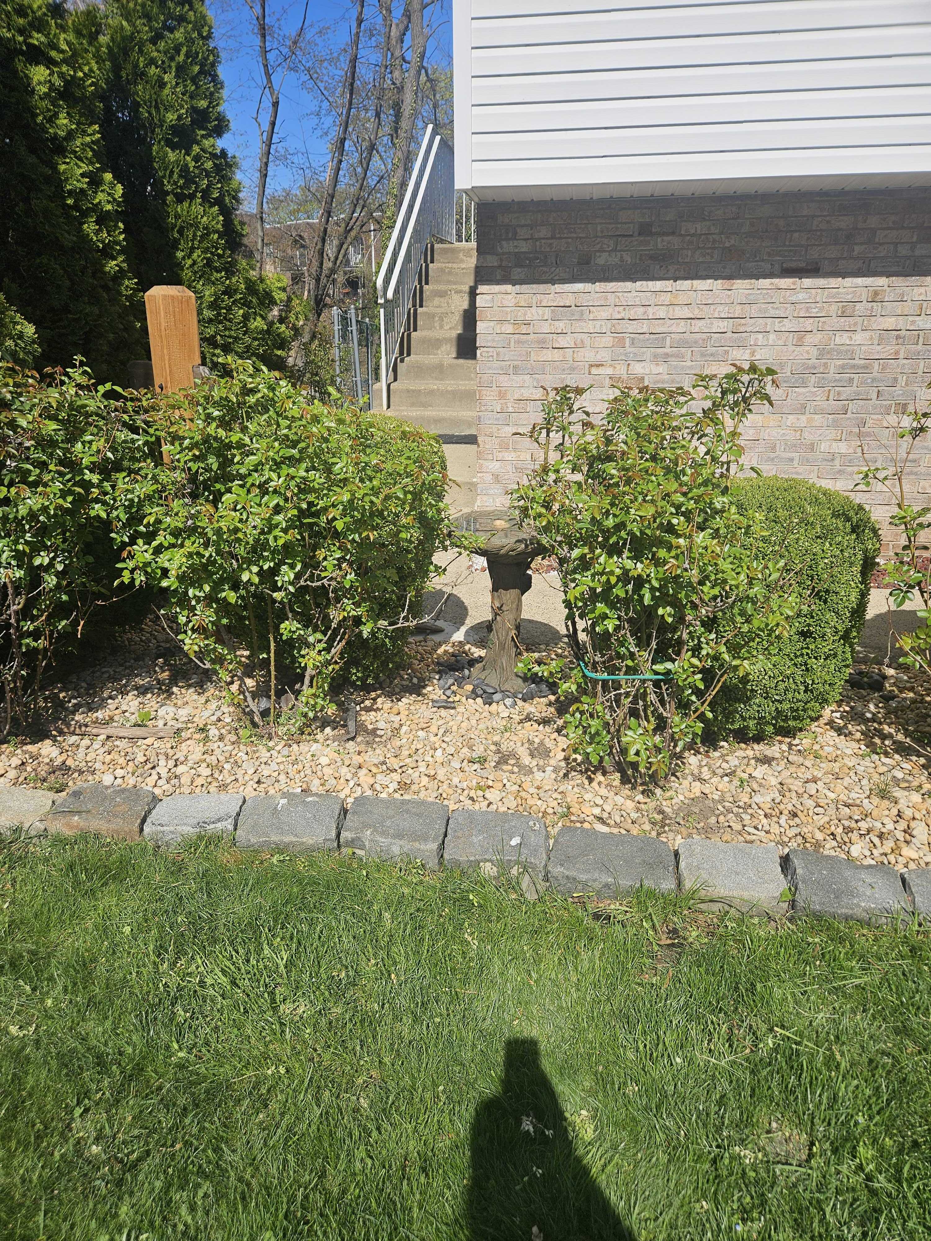 Front bed along the house with Belgian block border and river rock fill between the shrubs